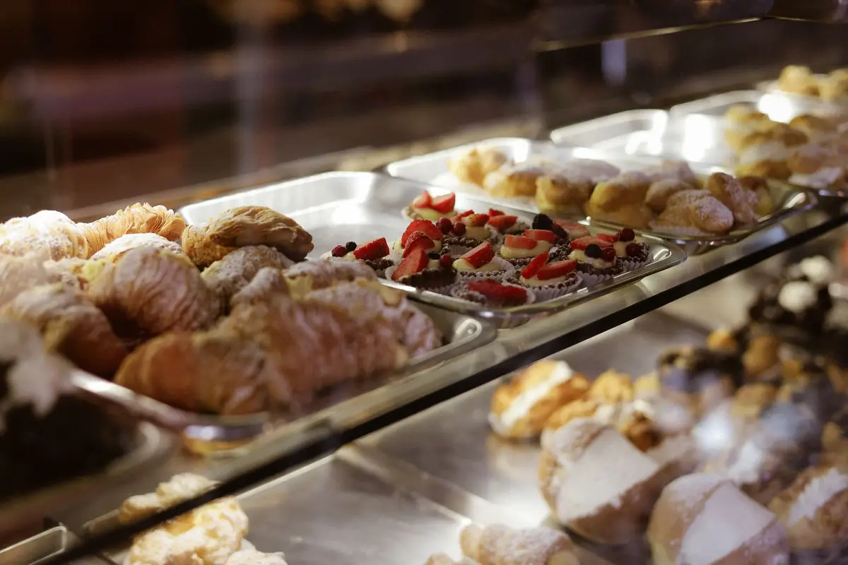 Bakery display case filled with croissants and pastries